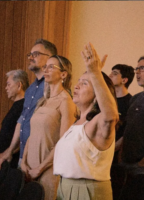 Famílias em pé adorando durante o culto