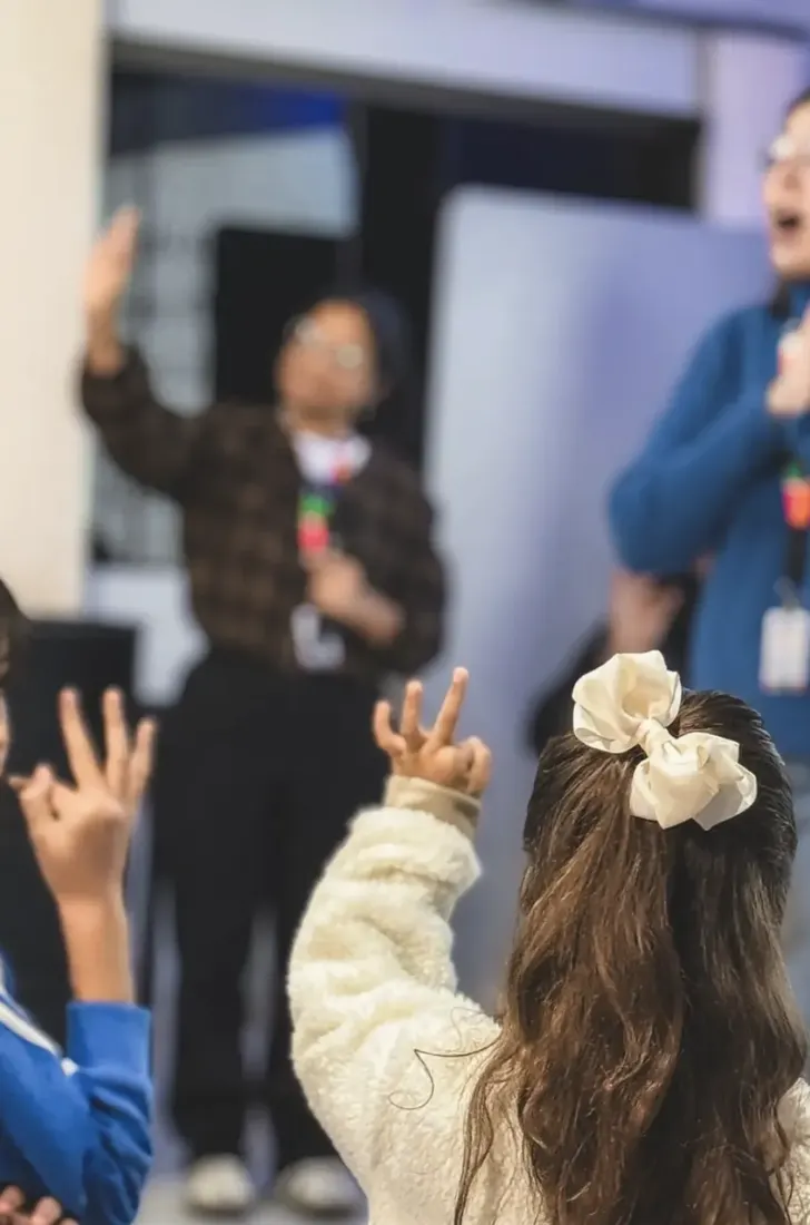 Crianças cantando com gestos durante o culto infantil
