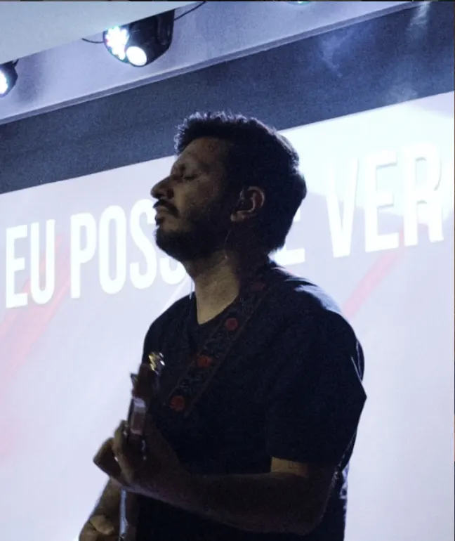 Músico de olhos fechados tocando violão