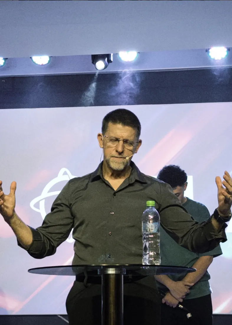 Pastor orando de braços abertos
